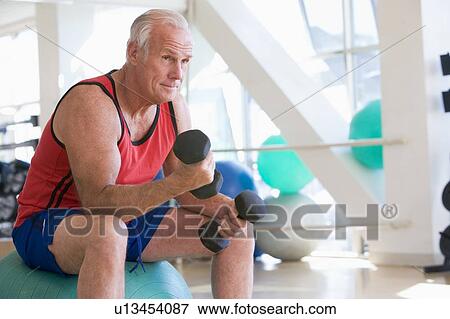 Man Using Hand Weights On Swiss Ball At Gym View Large Photo Image Stock Photo - Man Using Hand Weights On Swiss Ball At Gym. Fotosearch