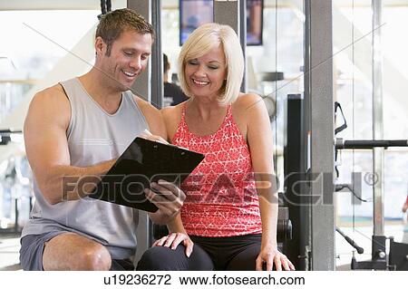 Personal Trainer Talking To Woman At Gym View Large Photo Image Stock Image - Personal Trainer Talking To Woman At Gym. Fotosearch