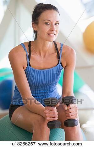 Woman Using Hand Weights On Swiss Ball At Gym View Large Photo Image Stock Photo - Woman Using Hand Weights On Swiss Ball At Gym. Fotosearch