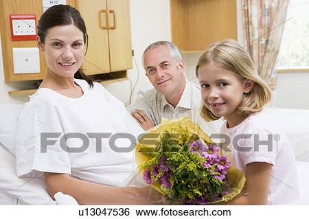 Stock Photograph - Daughter And Father Visiting Mother In Hospital. Fotosearch