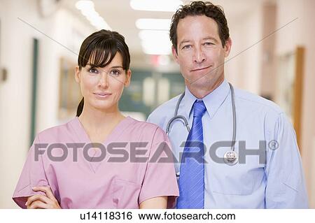 Stock Photograph - Doctor And Nurse Standing In A Hospital Corridor. Fotosearch