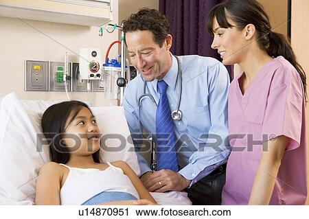 Stock Image - Doctor And Nurse Talking To Young Girl. Fotosearch