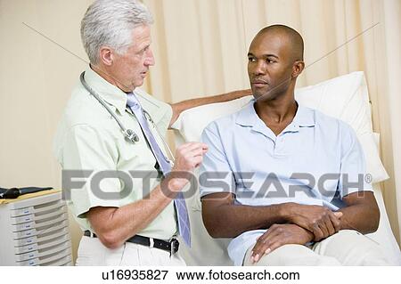 Stock Photo - Doctor giving man checkup in exam room. Fotosearch