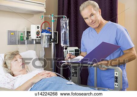 Stock Photo - Doctor Making Notes About His Patient. Fotosearch
