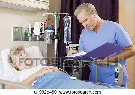 Stock Image - Doctor Making Notes About Patient. Fotosearch
