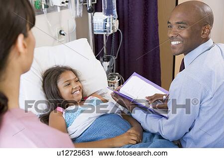 Stock Image - Doctor Making Notes On Young Girl . Fotosearch