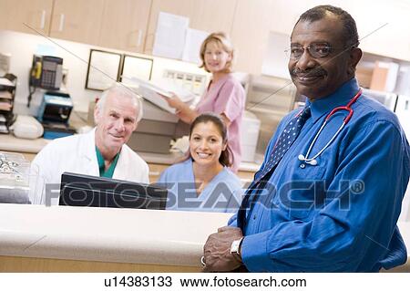 Stock Image - Doctors And Nurses At The Reception Area Of A Hospital. Fotosearch
