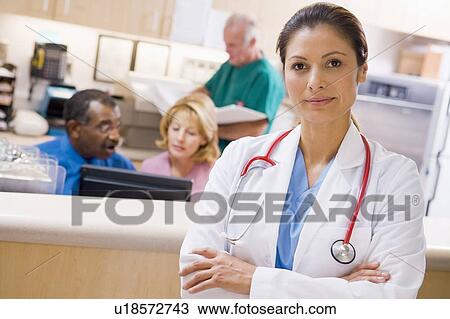Stock Image - Doctors And Nurses At The Reception Area Of A Hospital. Fotosearch