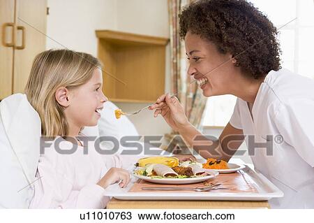 Stock Image - Nurse Feeding Young Girl. Fotosearch