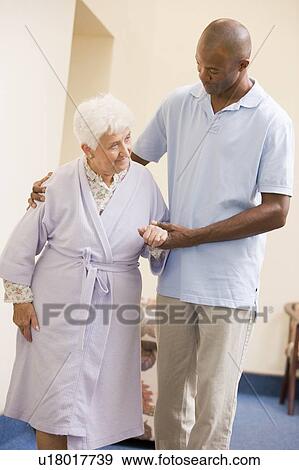 Stock Photo - Nurse Helping Senior Woman To Walk. Fotosearch
