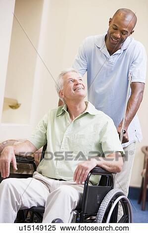 Stock Photography - Nurse Pushing Man In Wheelchair. Fotosearch
