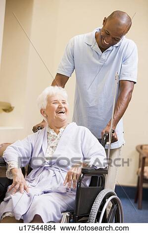 Picture - Nurse Pushing Senior Woman In Wheelchair. Fotosearch