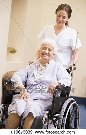 Stock Photo - Nurse Pushing Senior Woman In Wheelchair. Fotosearch