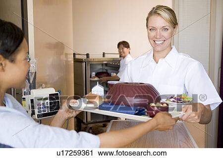 Stock Image - Nurse Serving A Patient A Meal In Her Bed. Fotosearch
