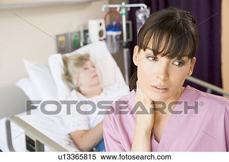 Stock Photography - Nurse Standing In Hospital Room, Looking Tired. Fotosearch