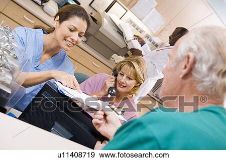 Nurses Discussing A Clipboard At The Reception Area In A Hospital View Large Photo Image Stock Photo - Nurses Discussing A Clipboard At The Reception Area In A Hospital. Fotosearch