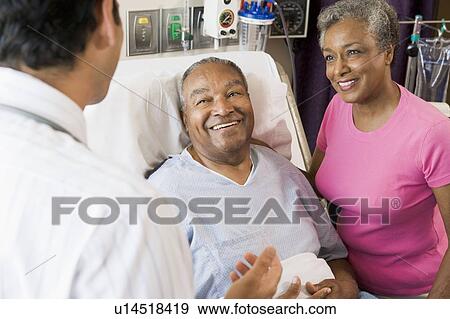 Senior Couple Talking, Smiling With Doctor View Large Photo Image Stock Photo - Senior Couple Talking, Smiling With Doctor. Fotosearch