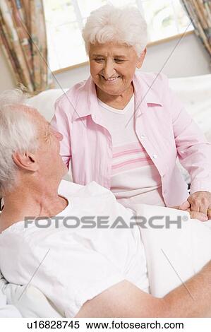 Stock Photography - Senior Woman Visiting Her Husband In Hospital. Fotosearch