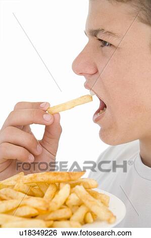 Boy eating French fries View Large Photo Image Stock Photograph - Boy eating French fries. Fotosearch