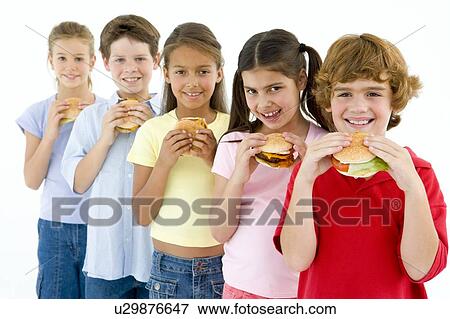 Stock Photo - Row of five young friends eating hamburgers. Fotosearch