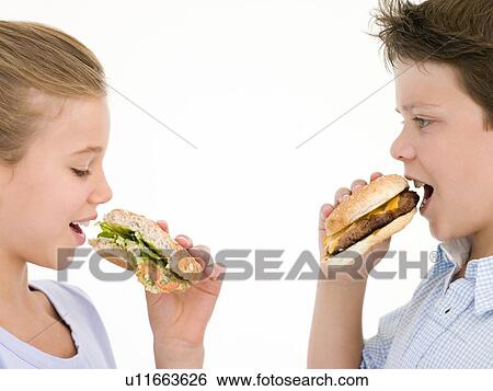 Sister eating sandwich by brother eating cheeseburger View Large Photo Image Stock Photograph - Sister eating sandwich by brother eating cheeseburger. Fotosearch