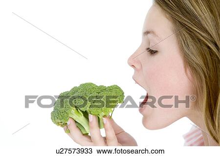 Teenage girl eating broccoli View Large Photo Image Stock Image - Teenage girl eating broccoli. Fotosearch