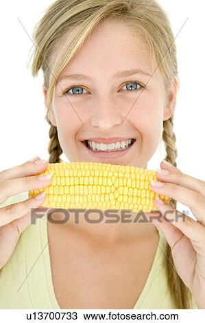 Teenage girl holding corn on cob and smiling View Large Photo Image Stock Image - Teenage girl holding corn on cob and smiling. Fotosearch