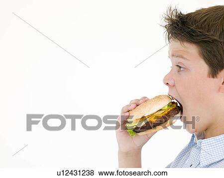 Young boy eating cheeseburger View Large Photo Image Stock Photo - Young boy eating cheeseburger. Fotosearch