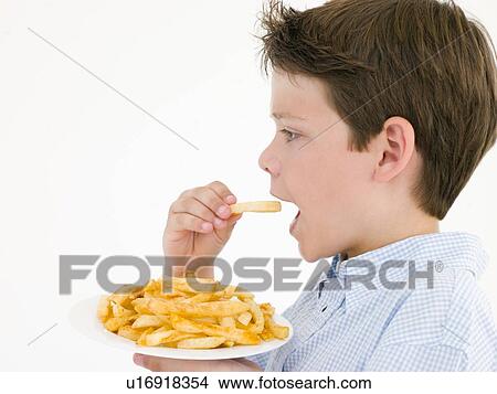 Young boy eating French fries View Large Photo Image Picture - Young boy eating French fries. Fotosearch