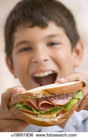 Young boy eating sandwich smiling View Large Photo Image Stock Photograph - Young boy eating sandwich smiling. Fotosearch