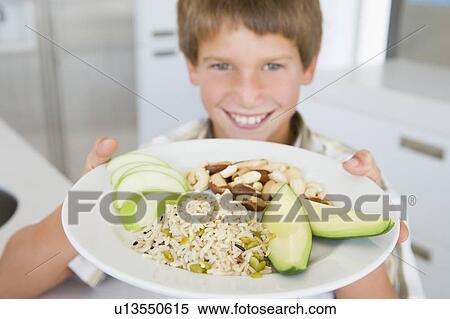Young boy in kitchen eating rice fruit and nuts smiling View Large Photo Image Stock Photography - Young boy in kitchen eating rice fruit and nuts smiling. Fotosearch
