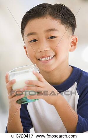 Young boy indoors drinking milk smiling View Large Photo Image Stock Photo - Young boy indoors drinking milk smiling. Fotosearch