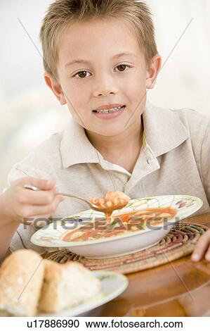 Young boy indoors eating soup View Large Photo Image Stock Image - Young boy indoors eating soup. Fotosearch
