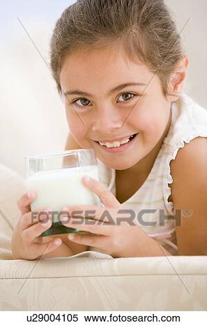 Young girl drinking milk in living room smiling View Large Photo Image Stock Photography - Young girl drinking milk in living room smiling. Fotosearch