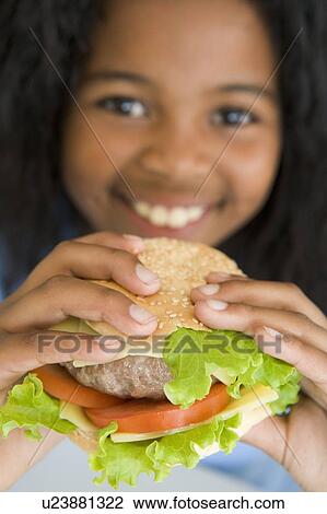 Young girl eating cheeseburger smiling View Large Photo Image Stock Image - Young girl eating cheeseburger smiling. Fotosearch