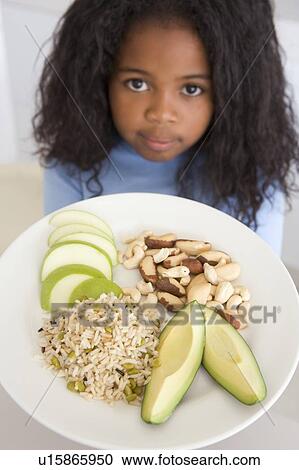 Young girl in kitchen eating rice fruit and nuts View Large Photo Image Stock Image - Young girl in kitchen eating rice fruit and nuts. Fotosearch