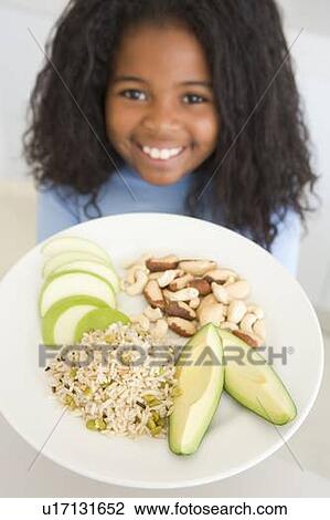 Young girl in kitchen eating rice fruit and nuts smiling View Large Photo Image Stock Image - Young girl in kitchen eating rice fruit and nuts smiling. Fotosearch