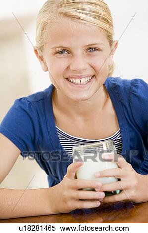 Young girl indoors drinking milk smiling View Large Photo Image Stock Photography - Young girl indoors drinking milk smiling. Fotosearch