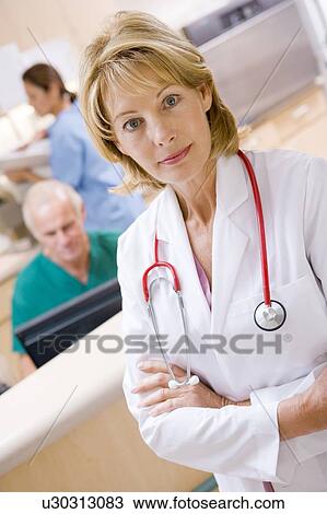 Stock Image - A Doctor And Nurses In The Reception Area Of A Hospital. Fotosearch