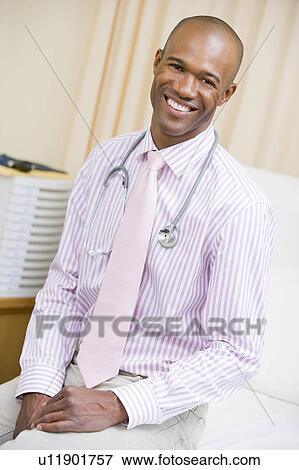 Stock Photo - A Doctor Sitting On A Hospital Bed. Fotosearch