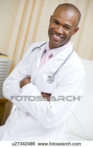Stock Photograph - A Doctor Sitting On A Hospital Bed. Fotosearch