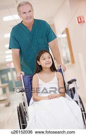 An Orderly Pushing A Little Girl In A Wheelchair Down A Hospital Corridor View Large Photo Image Stock Photograph - An Orderly Pushing A Little Girl In A Wheelchair Down A Hospital Corridor. Fotosearch