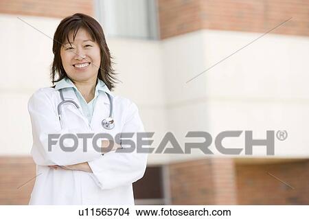 Doctor Standing Outside A Hospital View Large Photo Image Picture - Doctor Standing Outside A Hospital. Fotosearch