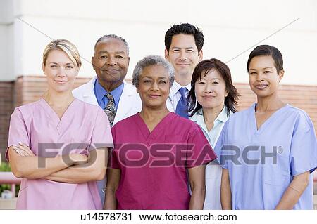 Stock Image - Hospital Staff Standing Outside A Hospital. Fotosearch