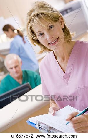 Stock Image - Nurses In The Reception Area Of A Hospital. Fotosearch