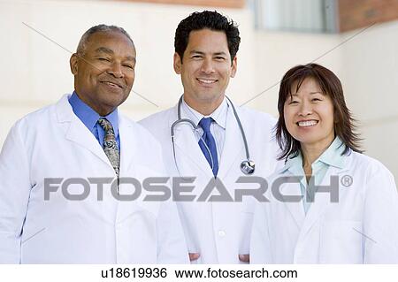 Stock Photograph - Three Doctors Standing Outside A Hospital. Fotosearch