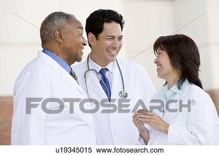 Stock Photography - Three Doctors Standing Outside A Hospital. Fotosearch