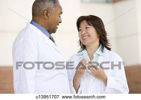 Stock Photo - Two Doctors Standing Outside A Hospital. Fotosearch