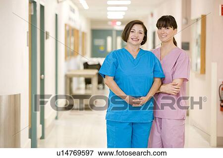 Stock Photo - Two Female Nurses Standing In A Hospital Corridor. Fotosearch