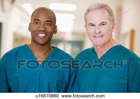 Stock Image - Two Orderlies Standing In A Hospital Corridor. Fotosearch